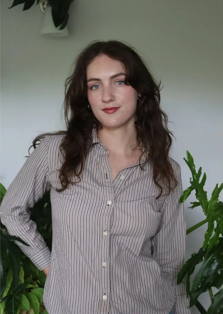 Savannah, founder of Plant Savvy, standing among houseplants